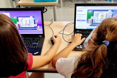 Alumnas de escuela estudiando programacion